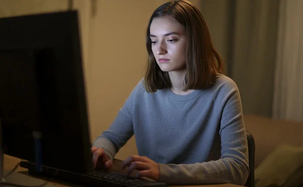 девушка в сером свитере сидит за компьютером грустная девушка сидит за компьютером